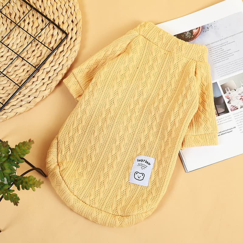 Yellow bear knit pet sweater on a warm tabletop